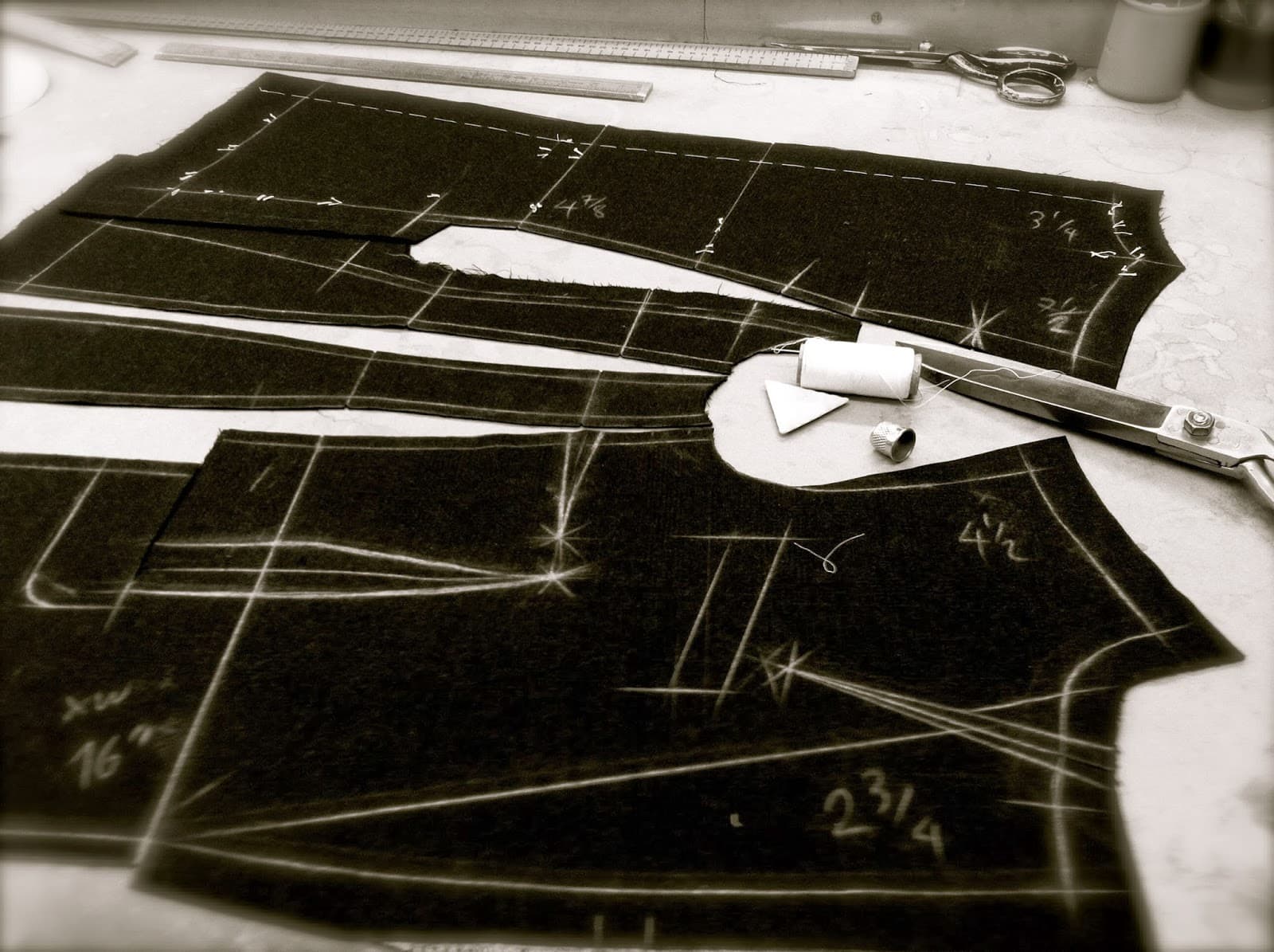 A pattern being cut by hand from suiting cloth